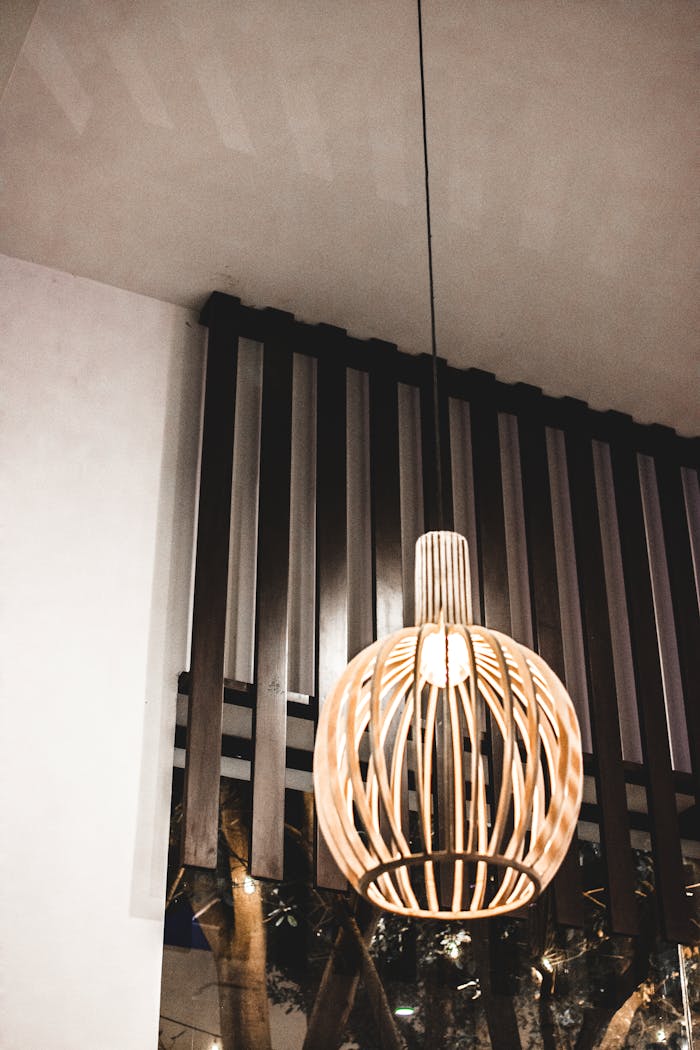 Elegant wooden pendant light in a contemporary indoor setting with sleek design elements.