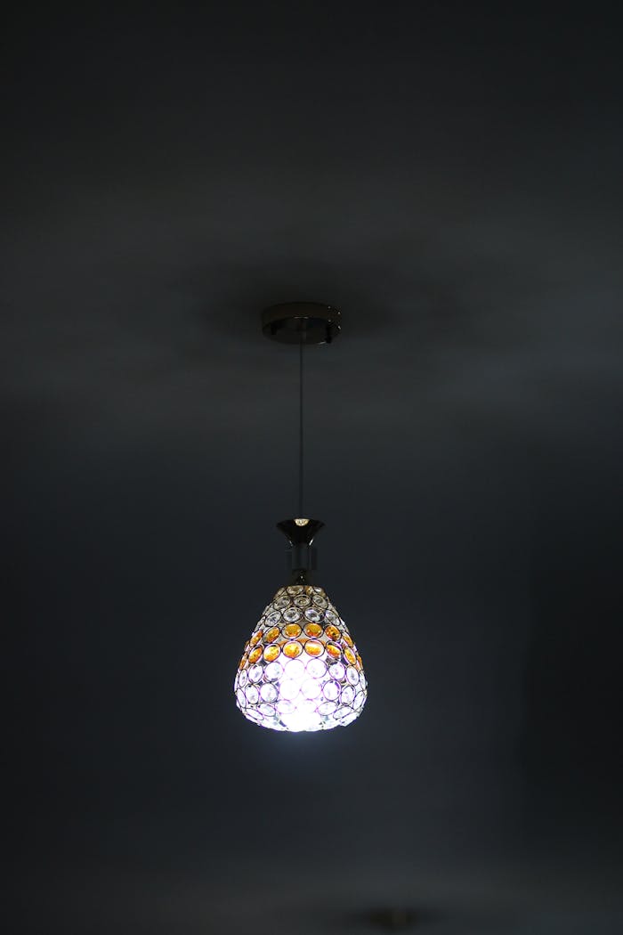 A beautiful chandelier lamp casting a warm glow in a dimly lit room, creating a cozy ambiance.