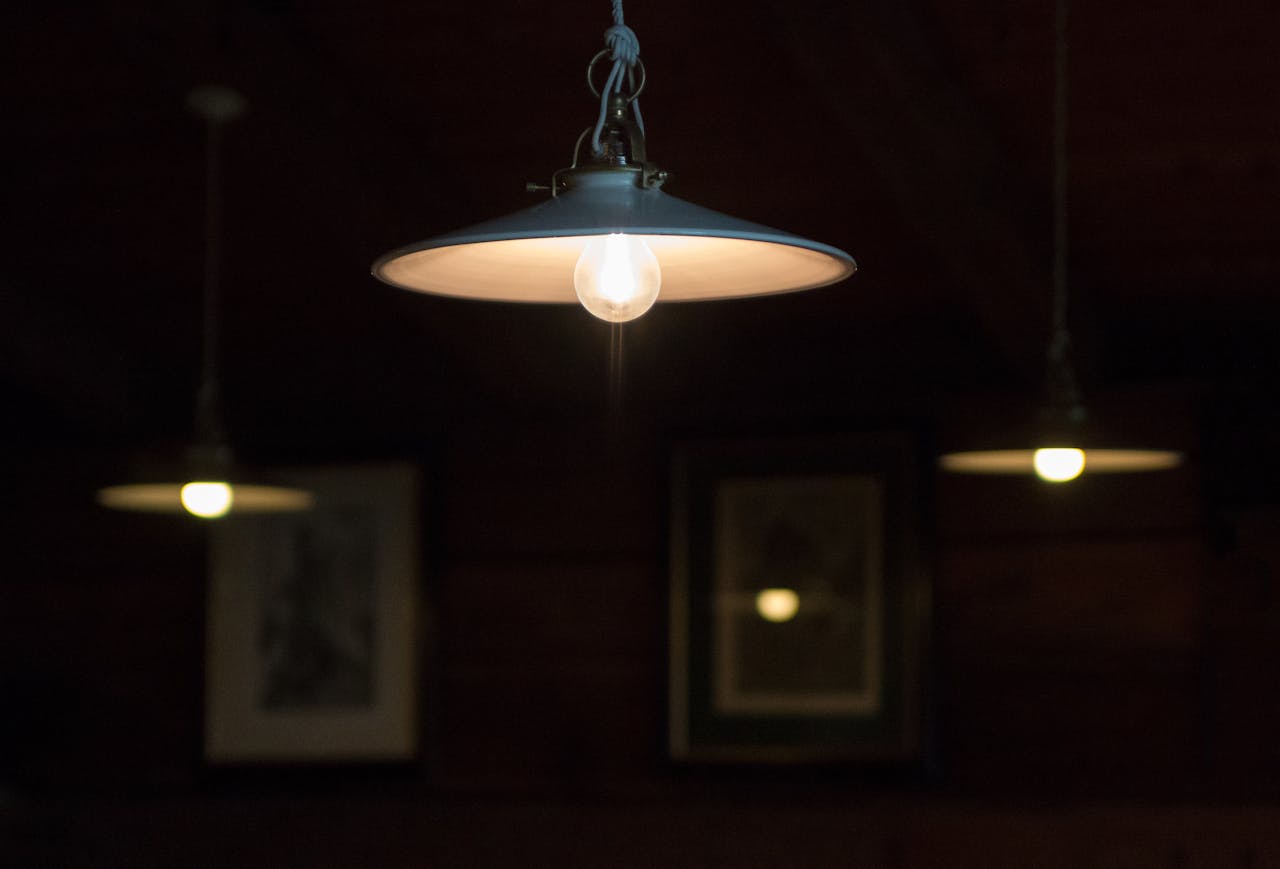 Moody indoor scene featuring hanging pendant lamps dimly lighting a cozy atmosphere.