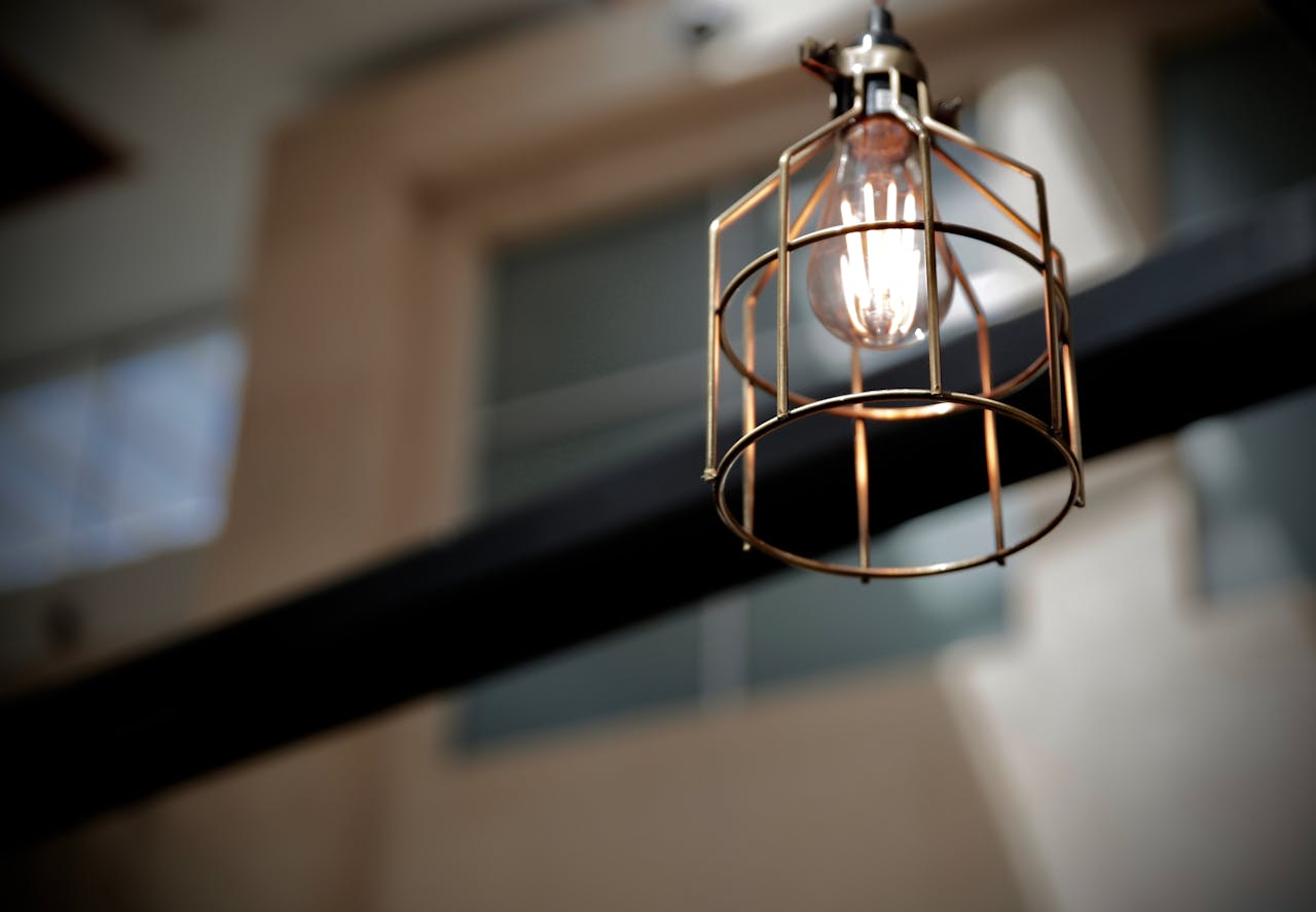 Close-up of a contemporary industrial-style metal lamp with an exposed light bulb.