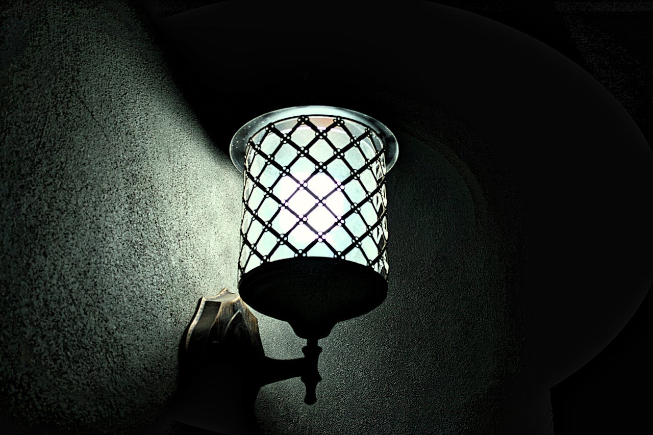 A close-up of a vintage wall lamp casting soft light in the dark. Elegant and artistic design.